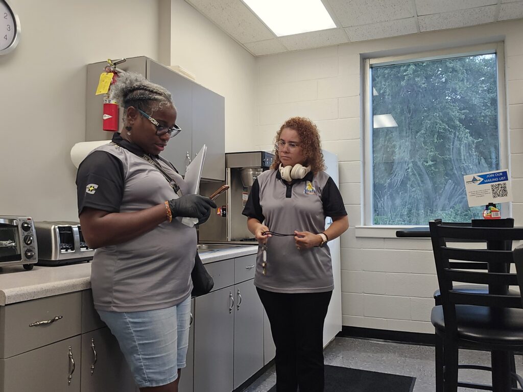 Two cleaners planning their routine in a professional offices breakroom